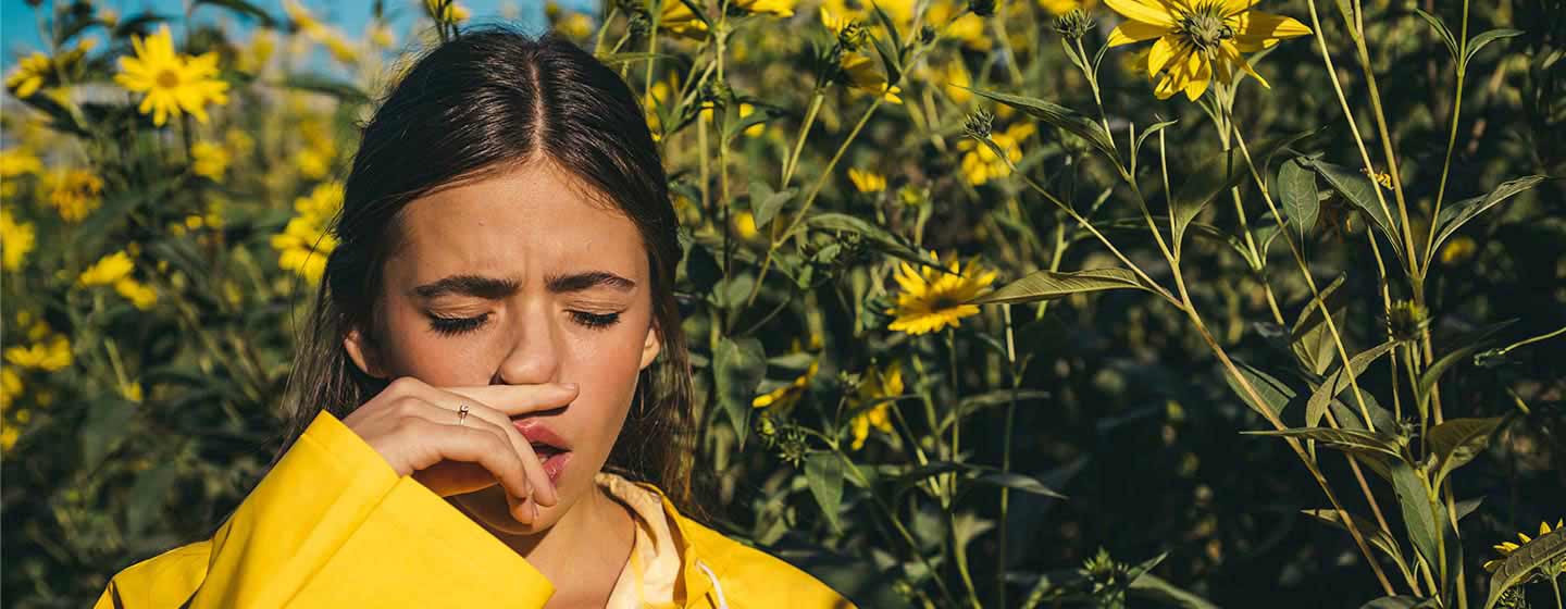 Una joven estornuda por la alergia - Rhinomer